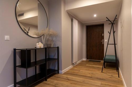 a hallway with a mirror on the wall and a chair at APartament Piaskowa in Gniewino
