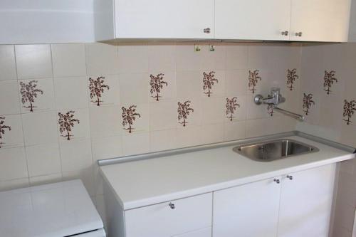 cocina con fregadero y pared de azulejos en NOVELLA 1 E 2, appartamenti a Numana con posto auto, en Numana