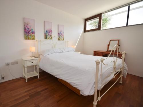 1 dormitorio con 1 cama blanca y 2 ventanas en 1 Bed in Westward Ho ASPRA en Westward Ho