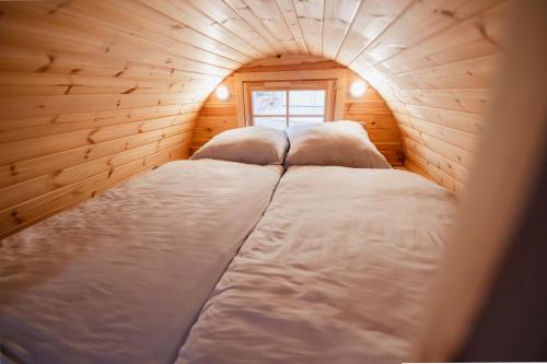 two beds in a wooden room with a window at Tiny House mit Wohnfass in Diez