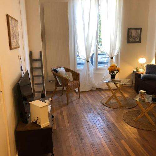 un salon avec un canapé, une télévision et une fenêtre dans l'établissement #M3 Irvoy's mystery Cours Jean Jaurès Tramway, à Grenoble