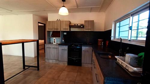 a kitchen with wooden cabinets and a black refrigerator at Balcones de playa de oro in Villa Independencia