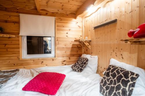 a bedroom with a bed in a wooden wall at Chata Julie in Mařenice