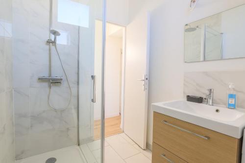 een badkamer met een glazen douche en een wastafel bij Appartement Calme - Arras Arrière Gare in Arras