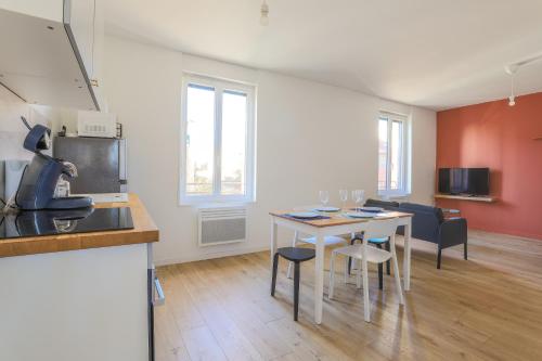 a kitchen and living room with a table and chairs at Appartement Calme - Arrière Gare - Parking Privée in Arras