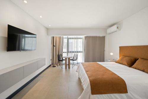 a bedroom with a bed and a flat screen tv at LV Puerto Madero in Buenos Aires