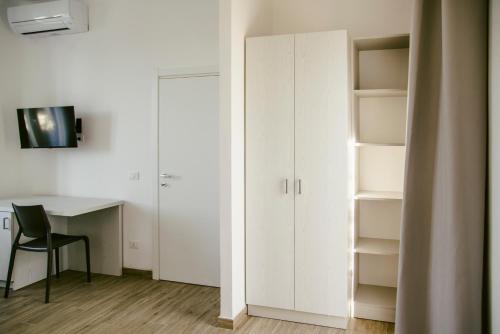 a room with a desk and a white closet at Residence Altair - Serra degli Alimini in Otranto