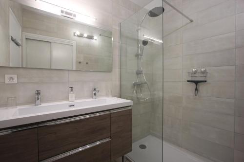 y baño con lavabo y ducha acristalada. en Gite de la rue du château - tout inclus en Pontgibaud