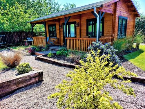 a log cabin with a landscaping in front of it at The Malvern Hills Courtyard Cabins. (Barbara Cabin) in Great Malvern