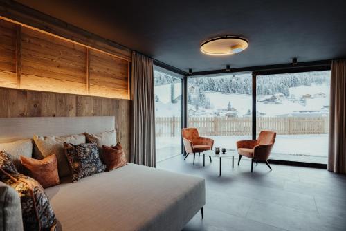a bedroom with a bed and a large window at Chalet Milé in Ortisei