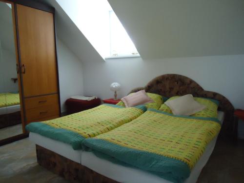 Schlafzimmer mit einem Bett mit grüner und gelber Bettwäsche in der Unterkunft Apartment Duhová in Franzensbad