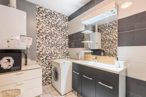 een badkamer met een wastafel en een wasmachine bij Grande Maison de Maître - Élégante avec Terrasse in Roubaix