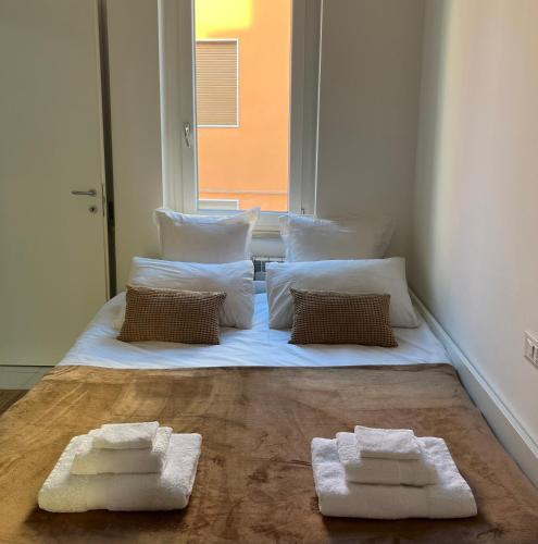 Una cama con dos toallas blancas en una habitación en Flatluxe Parma 1, en Parma
