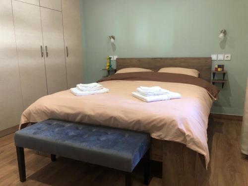 Schlafzimmer mit einem großen Bett und einer blauen Bank in der Unterkunft One Fine Stay in Piräus
