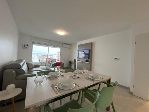 - une salle à manger avec une table, des chaises et un canapé dans l'établissement le Bel Alpin, à Annecy