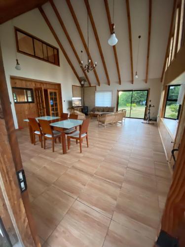 Casa de Campo في أوسورنو: غرفة معيشة كبيرة مع طاولة وكراسي