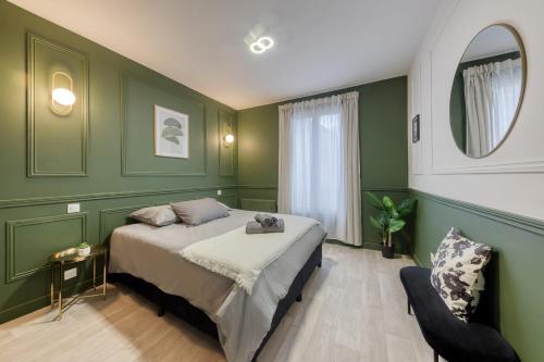 1 dormitorio con paredes verdes, 1 cama y 1 silla en Beautiful apartment - Cozy - Near Paris, en LʼÎle-Saint-Denis