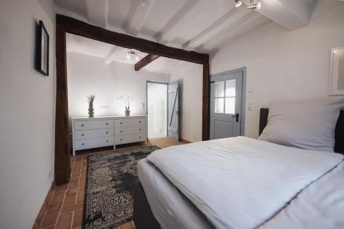 Schlafzimmer mit einem weißen Bett und einem Spiegel in der Unterkunft Altstadt Märchen-Fachwerkhaus in Limburg an der Lahn