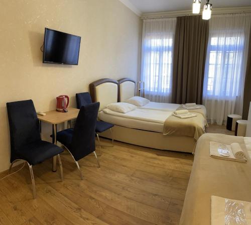 Habitación de hotel con cama, mesa y sillas en Guest House Lusi, en Tiflis