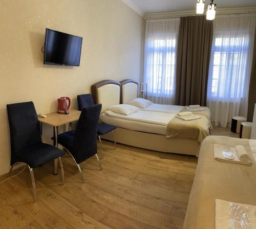 a hotel room with a bed and a table and chairs at Guest House Lusi in Tbilisi City