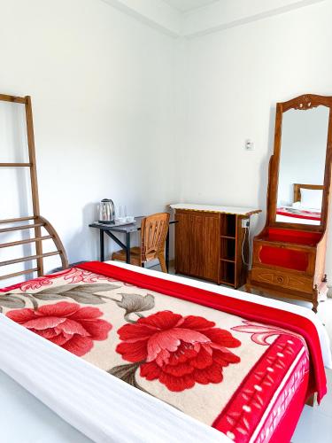 a bedroom with a bed with a red and white blanket at Heaven Hills Guest House in Maskeliya