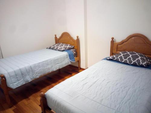 Habitación pequeña con 2 camas y suelo de madera. en Costa Lodges, Shared Room Funchal or Santa Cruz, en Santa Cruz