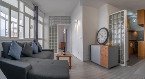 een woonkamer met een bank en een klok aan de muur bij Duas Torres View Apartment in Funchal