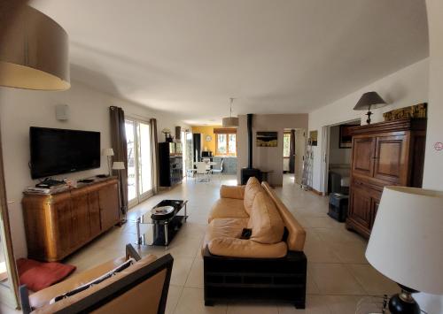un salon avec un canapé et une télévision à écran plat dans l'établissement Villa 4P - Piscine privée sur terrain privé & clos 1400m2 - Au coeur de la Provence verte - Chien OK, à Rians