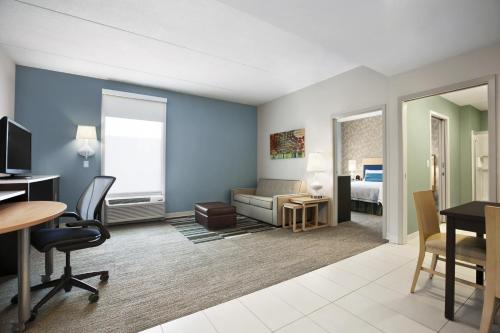 een woonkamer met een bureau en een kamer bij Home2 Suites By Hilton Winter Garden in Orlando