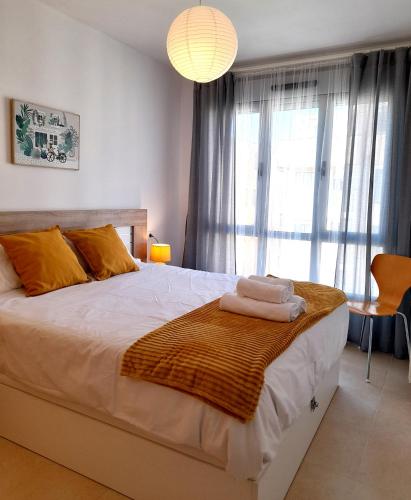 a bedroom with a large bed with towels on it at Gestiona2R - Apartamento Lita in Posada de Llanes