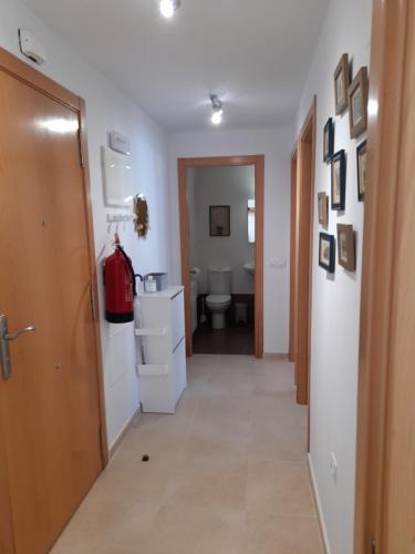 a hallway with a bathroom with a toilet and a door at Gestiona2R - Apartamento Lita in Posada de Llanes
