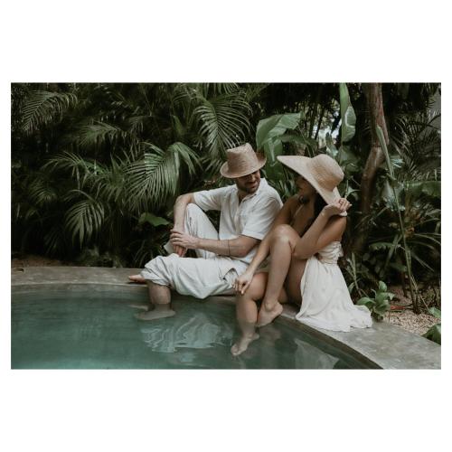 a man and a woman sitting next to a swimming pool at CASA CHAKÁ BOUTIQUE in Mérida