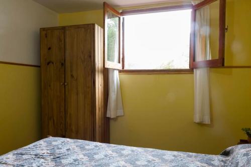 a bedroom with a bed and a window at Alojamiento frente al Arroyo Cristal in Tanti