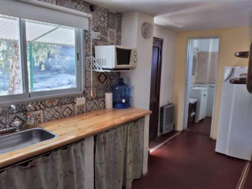 a kitchen with a counter with a sink and a window at Alojamiento frente al Arroyo Cristal in Tanti