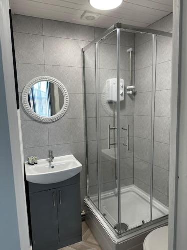 a bathroom with a shower and a sink and a mirror at Kos apartment 2 in Walton on the Hill