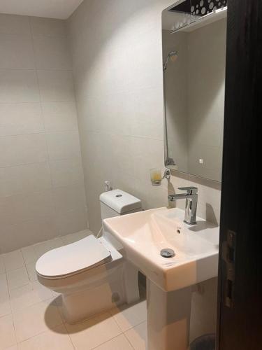 ein Badezimmer mit einem weißen WC und einem Waschbecken in der Unterkunft ريزا الفندقية Reeza Suites in Khobar