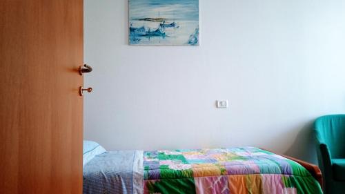 1 dormitorio con 1 cama y una pintura en la pared en Appartamento Che Vista! Affittacamere, en Mombaroccio