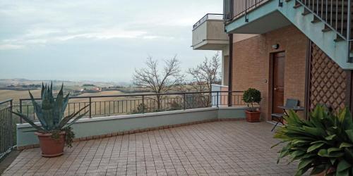 a balcony of a building with plants on it at Appartamento Che Vista! Affittacamere in Mombaroccio