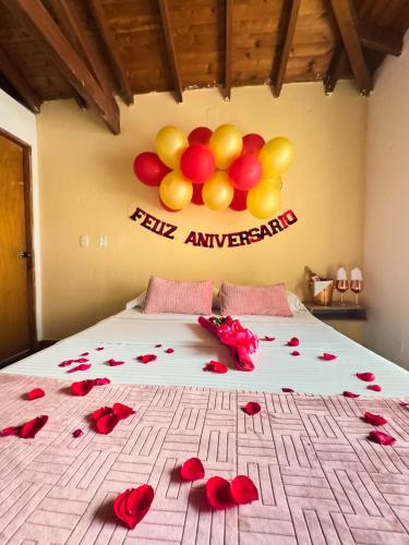 a bed with red roses and balloons on the wall at Encomendero Hotel -Centro Histórico- in Santa Fe de Antioquia