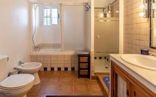 een badkamer met een toilet, een wastafel en een douche bij Casa Rural La Escuela in Arcos de la Frontera