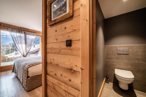 a bathroom with a wooden door leading to a bedroom at Chalet Heavenly Morzine - by EMERALD STAY in Montriond