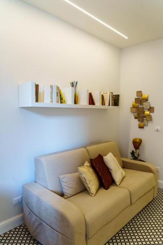 a couch in a living room with books on the wall at Le Volte And Suite in Catania