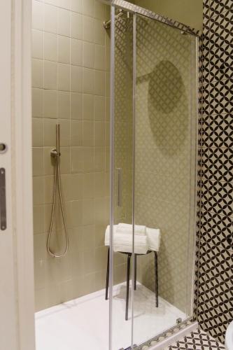 a glass shower with a stool in a bathroom at Le Volte And Suite in Catania