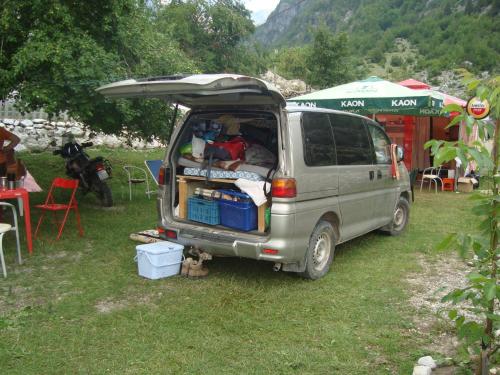 a van parked in the grass with its door open at Guesthouse Marashi in Theth