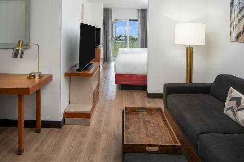 a living room with a couch and a bed in a hotel room at SpringHill Suites by Marriott Charleston Riverview in Charleston