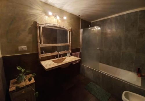 uma casa de banho com um lavatório, um espelho e uma banheira em Casa en un pueblo em Cañuelas
