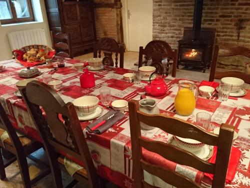 une table à manger avec un tissu de table rouge et blanc dans l'établissement A La Poularde B&B, à Curciat-Dongalon