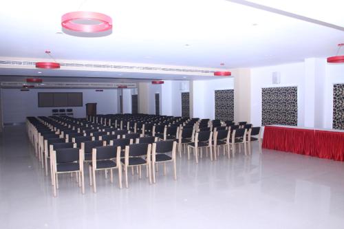 a large room with a rows of chairs and a stage at Hotel Hills Park Pathanamthitta in Pathanāmthitta