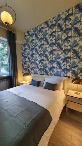 1 dormitorio con 1 cama grande y pared azul en Blue Palm Jungle Studio Self Checkin Design, en Milán