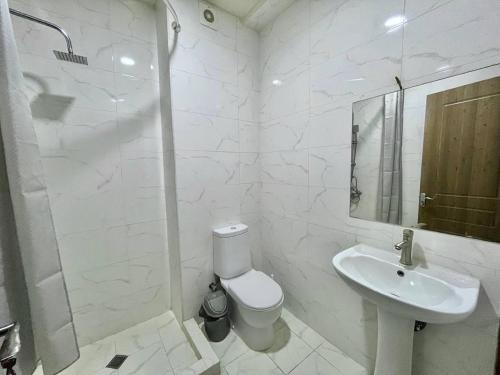a white bathroom with a toilet and a sink at Heven of Chilovski in Filipów